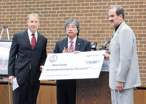 Jim Cheng, Virginia Secretary of Commerce and Trade, presents a $175,00 Governor's Opportunity Fund check to Jim Adams (right), chairman of the Henry County Board of Supervisors, and Steve Phillips (left), CEO of Commonwealth Laminating & Coating.